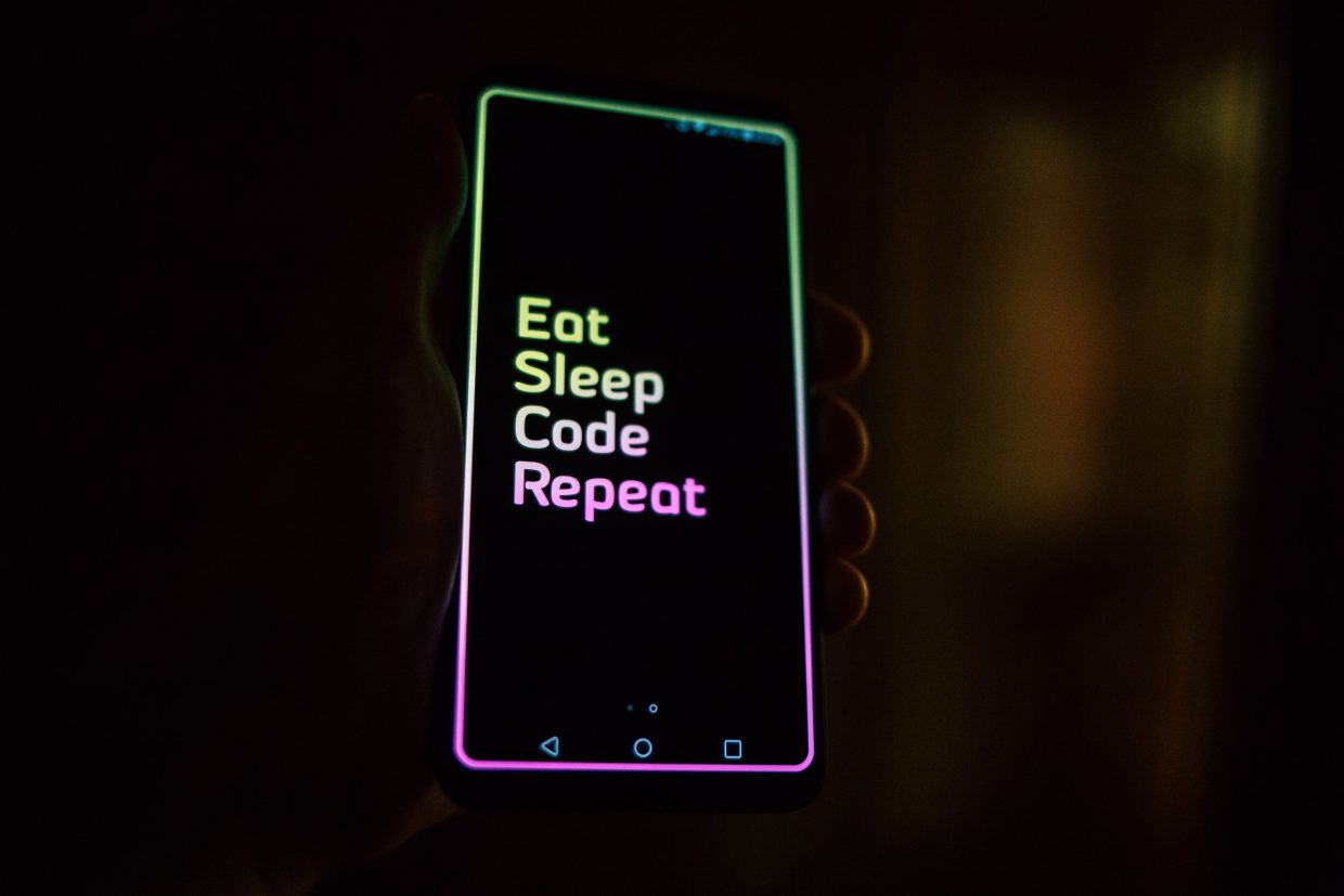 Mobile Phone Screen mit den Worten "Eat, Sleep, Code, Repeat"